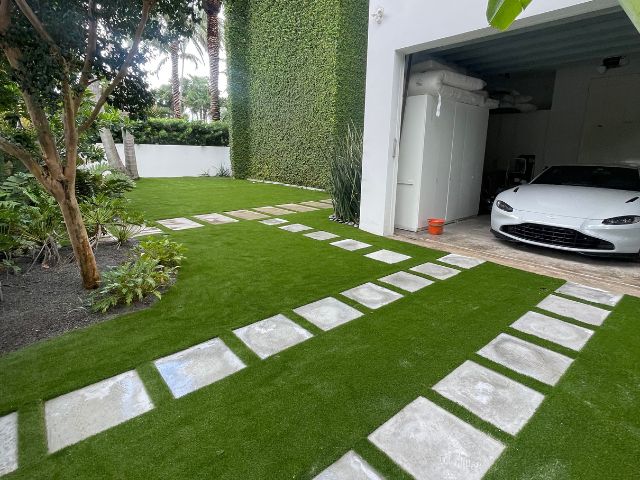 A skilled On-Time Turf team member installing artificial grass in Coconut Grove, FL, ensuring a flawless, professional finish.