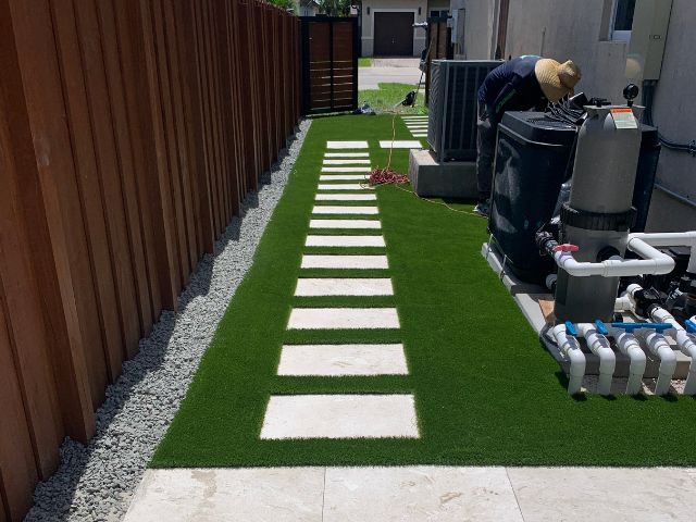 An On-Time Turf professional showcasing the benefits of artificial grass installation in Kendall, FL, including durability and eco-friendliness.